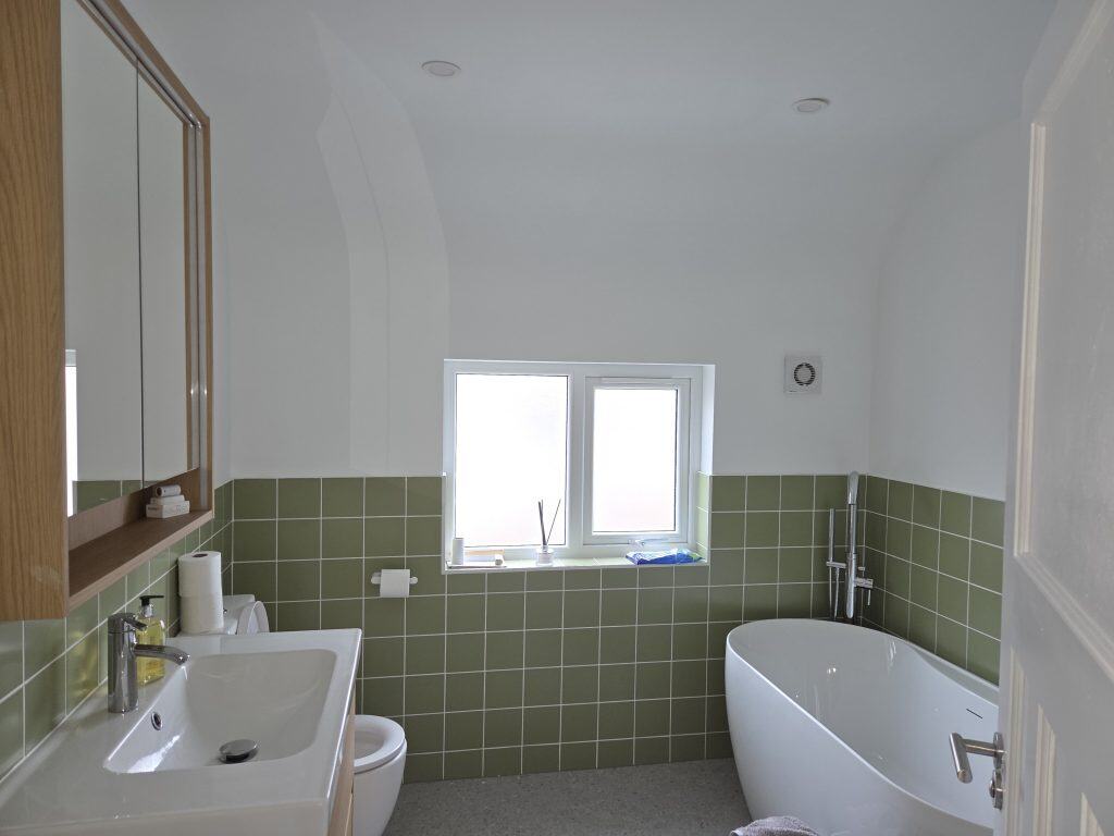Modern bathroom with green tiled interior walls
